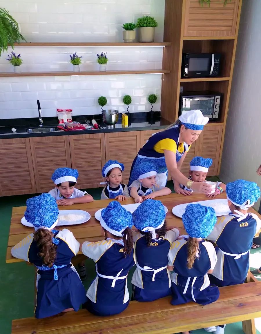 Crianças de touca e avental em uma aula de culinária