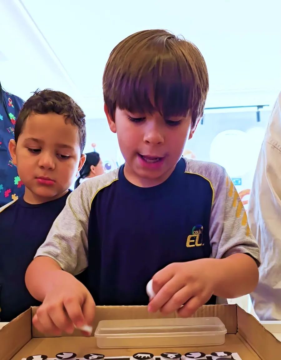 Dois meninos jogando damas em uma atividade